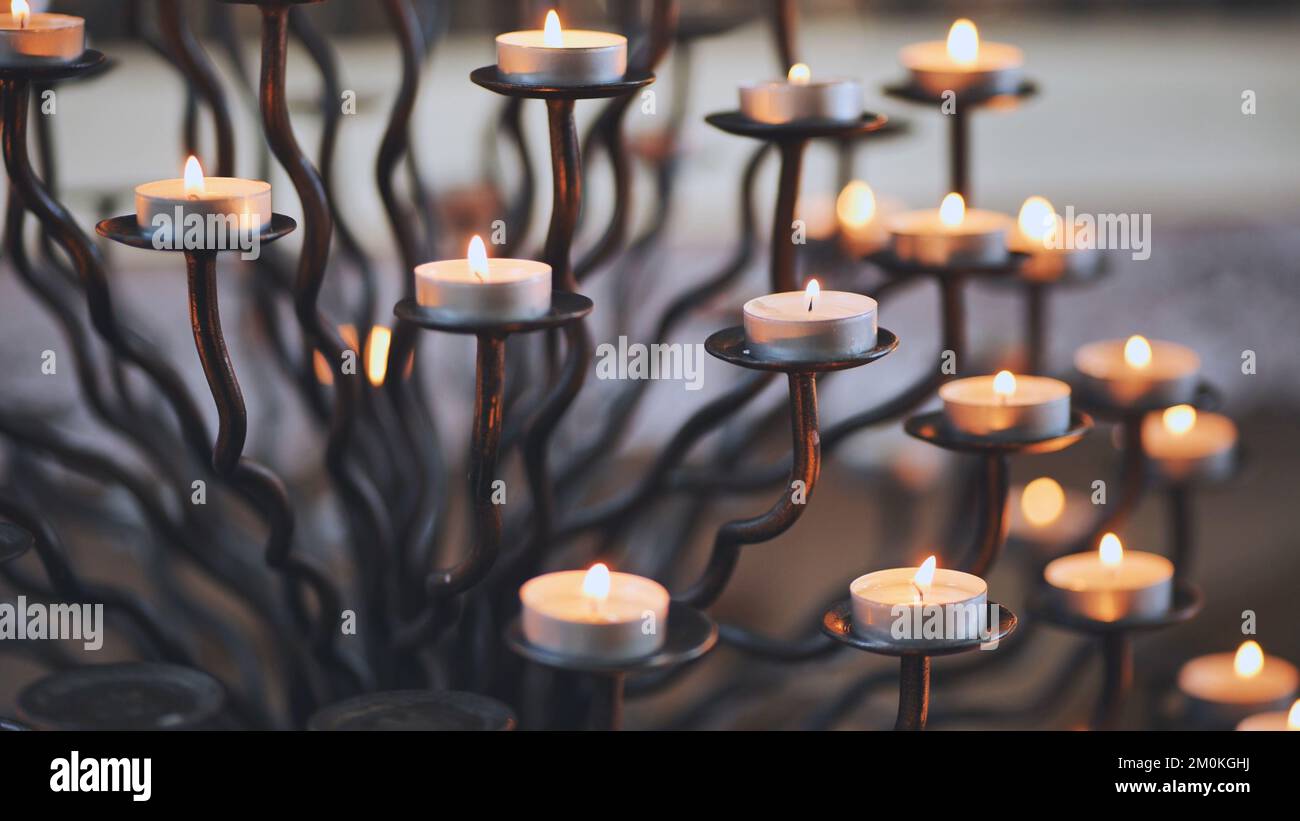 Candlestick holder with burning candles in a Catholic church Stock Photo -  Alamy