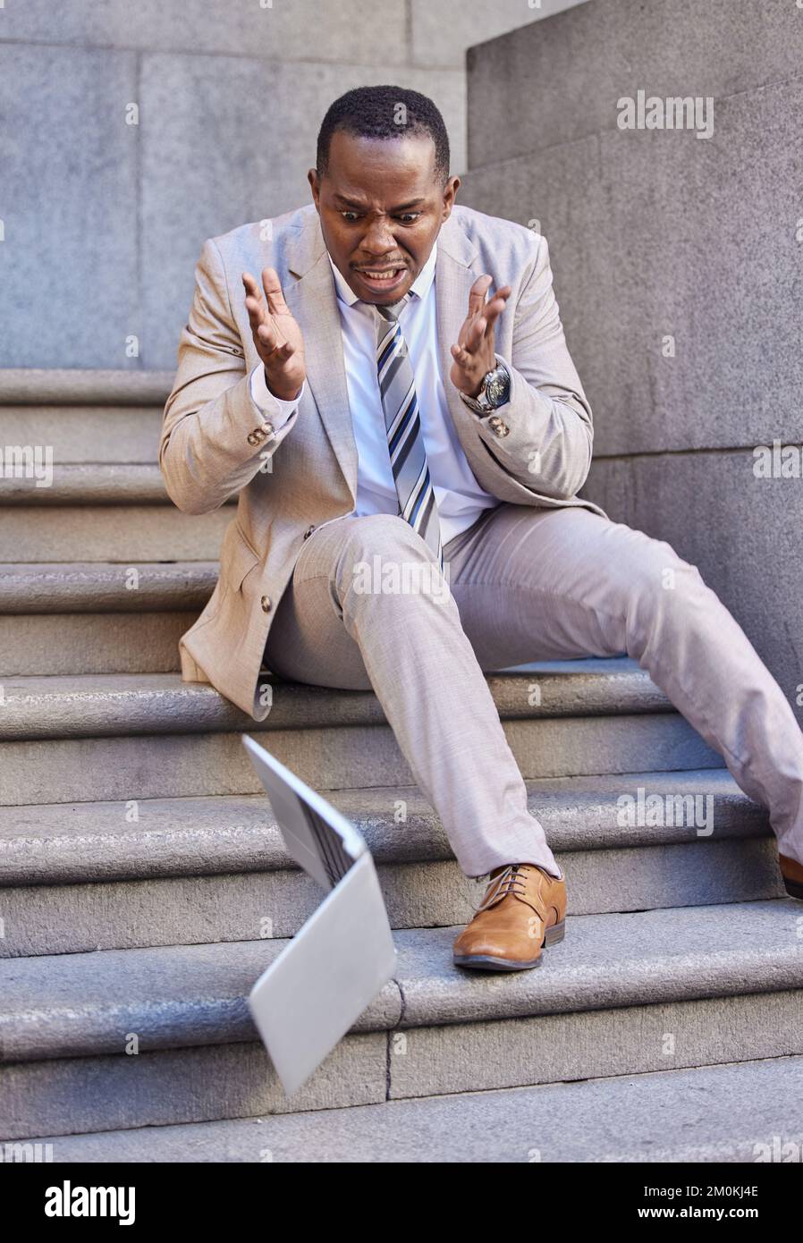 Businessman, laptop and mistake with damage, drop and fail while typing or reading email outdoor in the city. Black man, pc or technology with Stock Photo