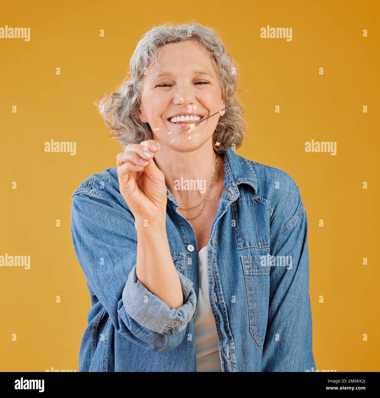 One happy mature caucasian woman playing with a sparkler on her