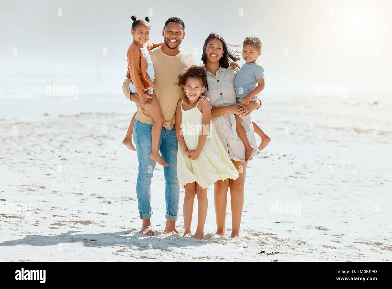 Portrait of a cheerful mixed race family with three children standing