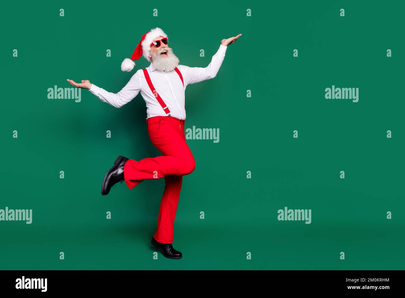 Full length photo of funky impressed senior guy wear x-mas costume walking empty space isolated green color background Stock Photo