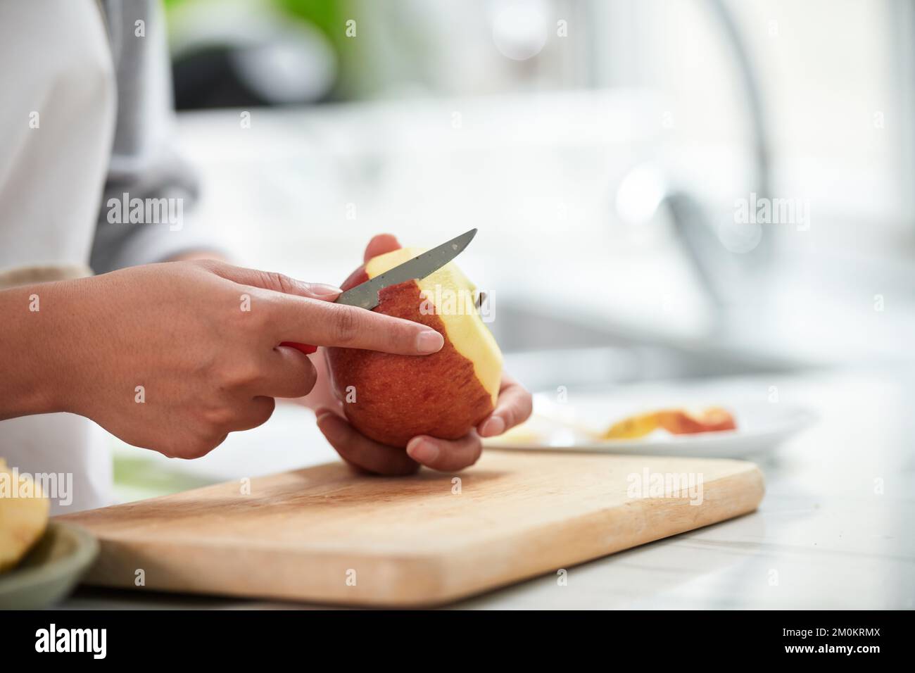 Woman peeling apple before eating, vitamin and fiber concept Stock