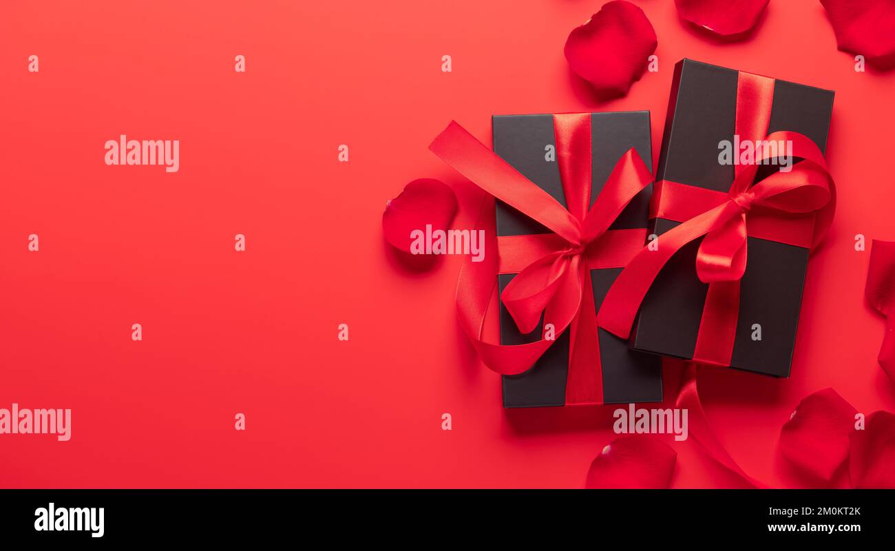 Valentines day card with gift boxes and rose flower petals. On red ...