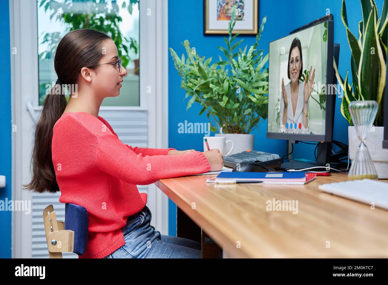 Video conference, teen girl student talking to teacher on screen Stock