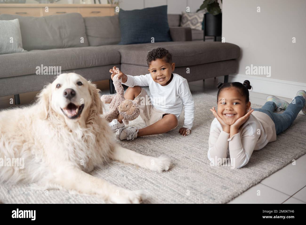 Two young mixed race siblings playing on the lounge floor with their