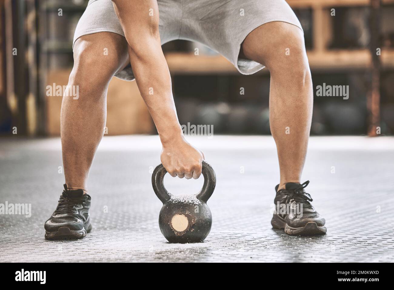 Fit athlete lifting a heavy kettlebell. Strong bodybuilder doing an arm