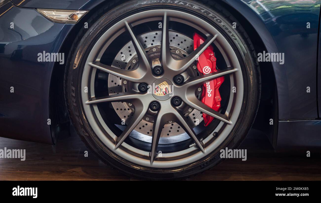 A closeup of the Porsche Cayman S wheel with red brake caliper, satin silver wheel Stock Photo