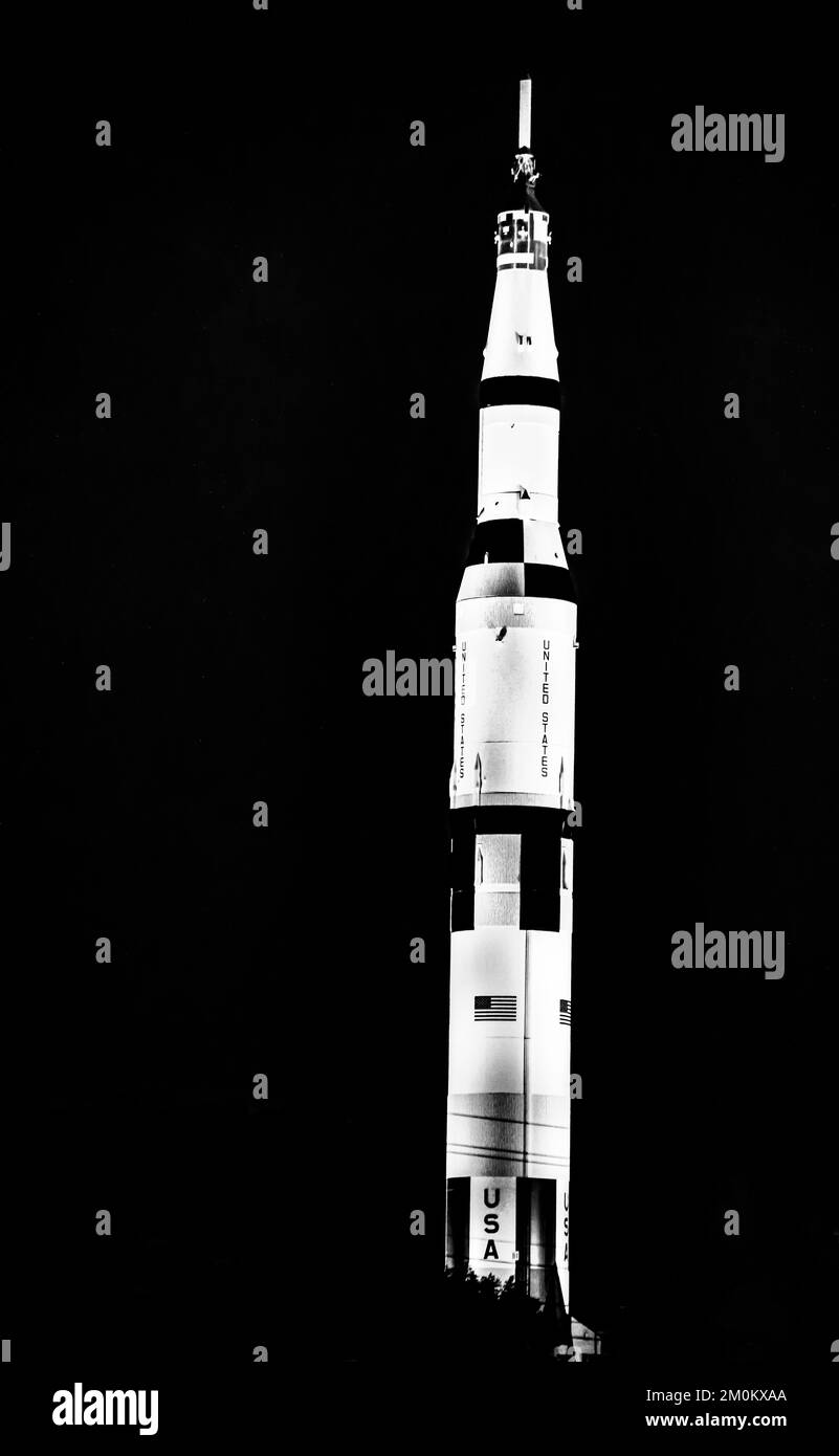 A grayscale of Saturn V NASA rocket against a sunset sky at the space