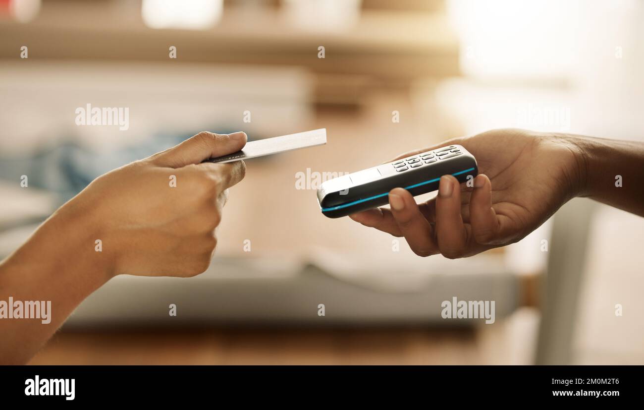 Customer paying designer using credit card and NFC machine. Business owner using contactless card machine. Entrepreneur accepting payment from a Stock Photo