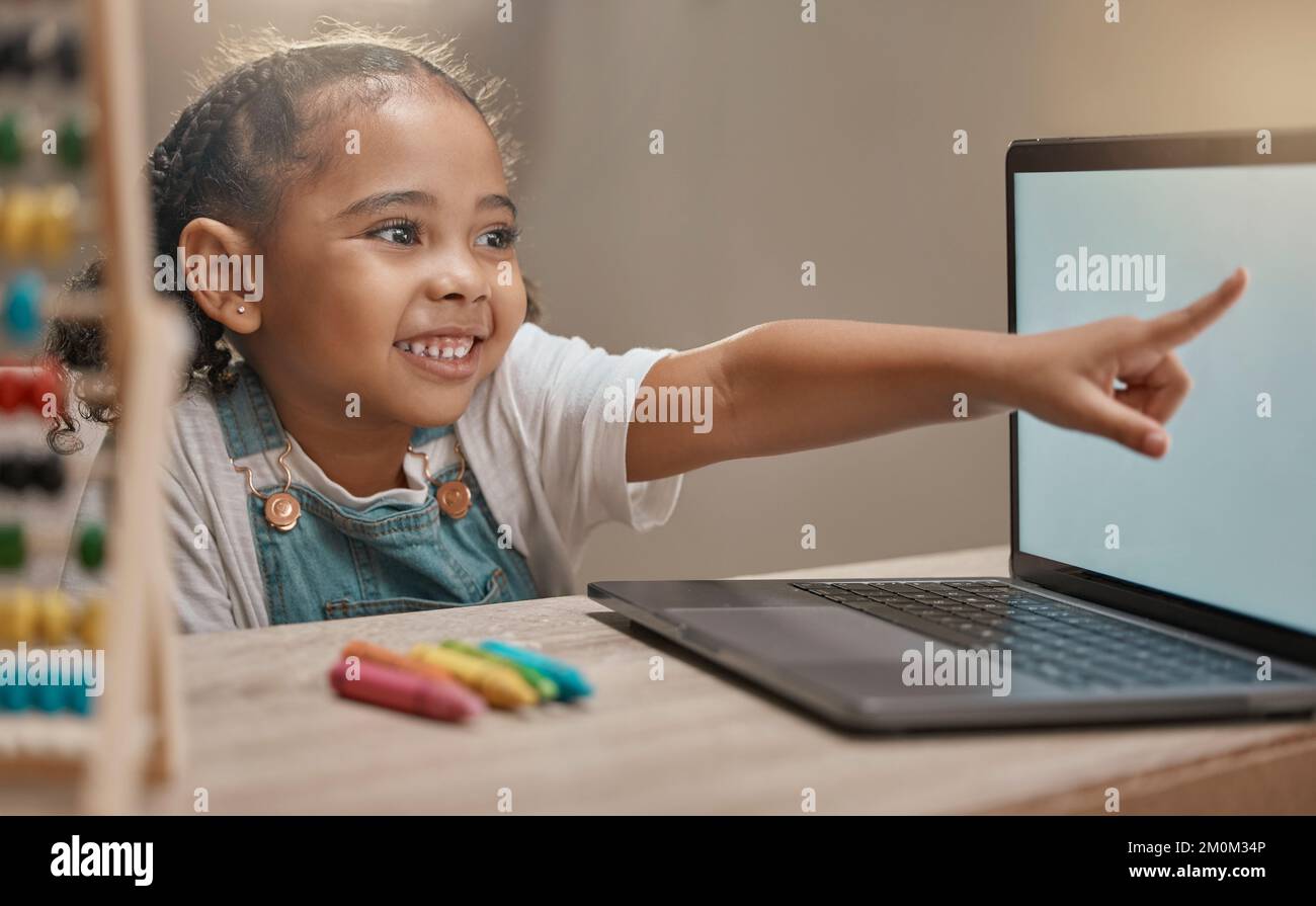 Education, home school and elearning with a student girl pointing at a laptop while studying for development. Computer, math and internet with a Stock Photo