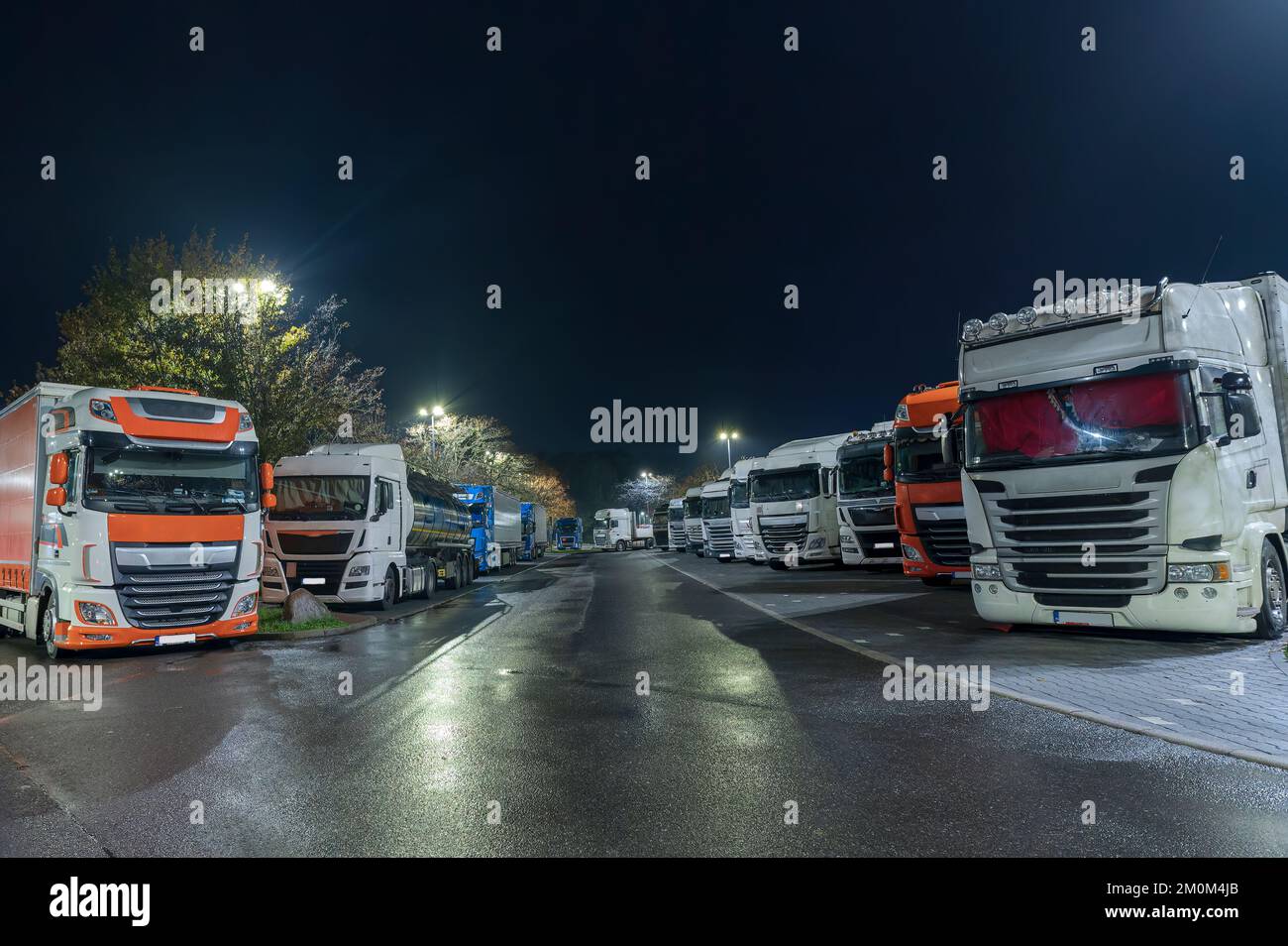 Everyday life on German motorway car parks, too few spaces for the trucks, which therefore have to park partly on car parking spaces. Stock Photo