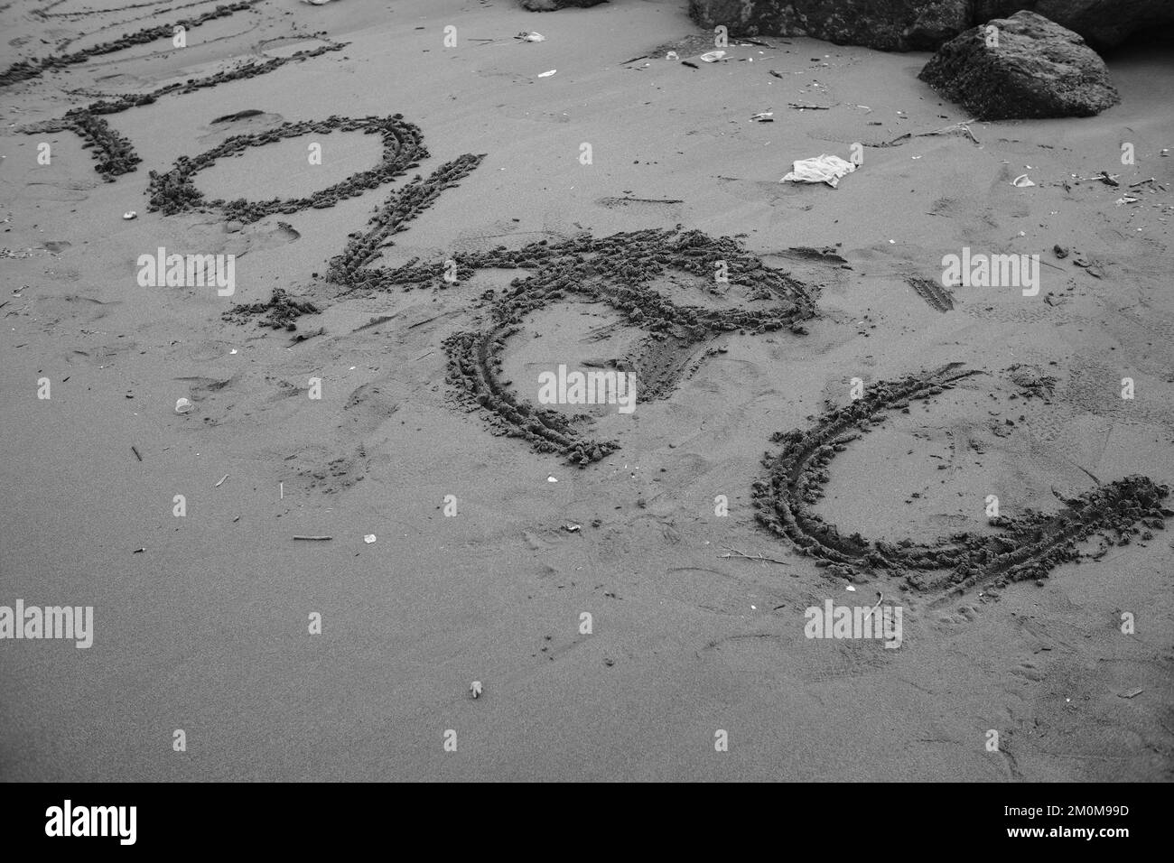 Black and white photo, Monochrome photo of a word 'i love u' on the beach sand Stock Photo