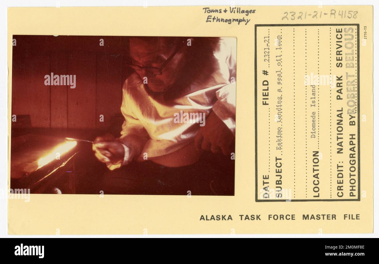 Eskimo tending a seal oil lamp. Alaska Task Force Photographs Stock