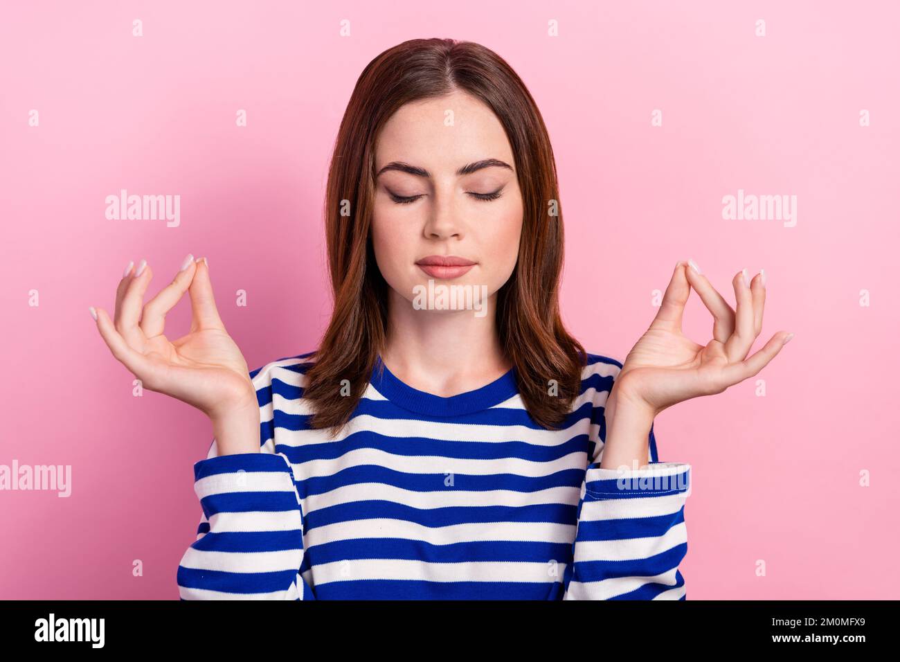 Portrait of calm pretty girl closed eyes arms fingers meditate concentrate isolated on pink color background Stock Photo