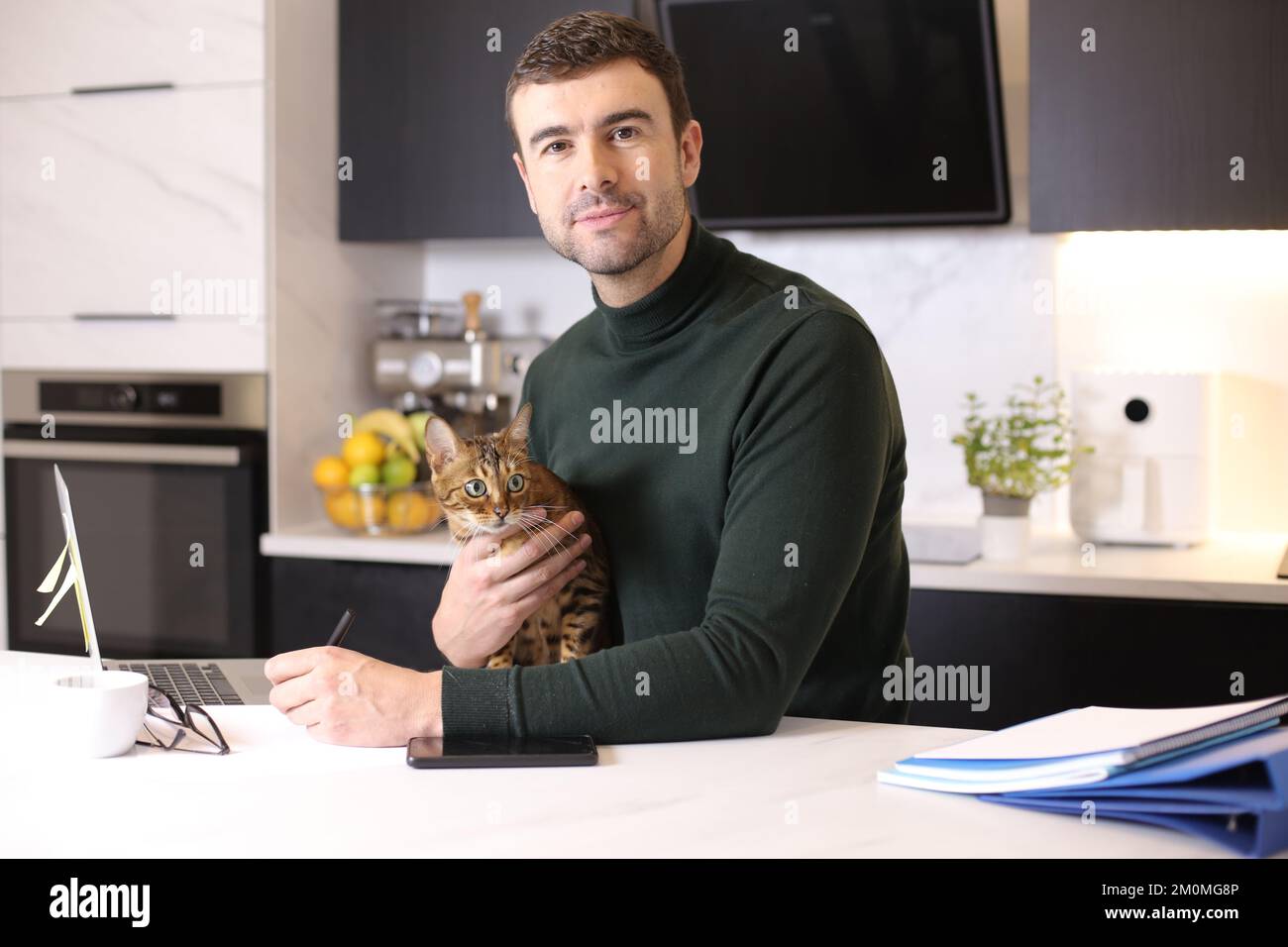 Attractive man working from home with his cat Stock Photo