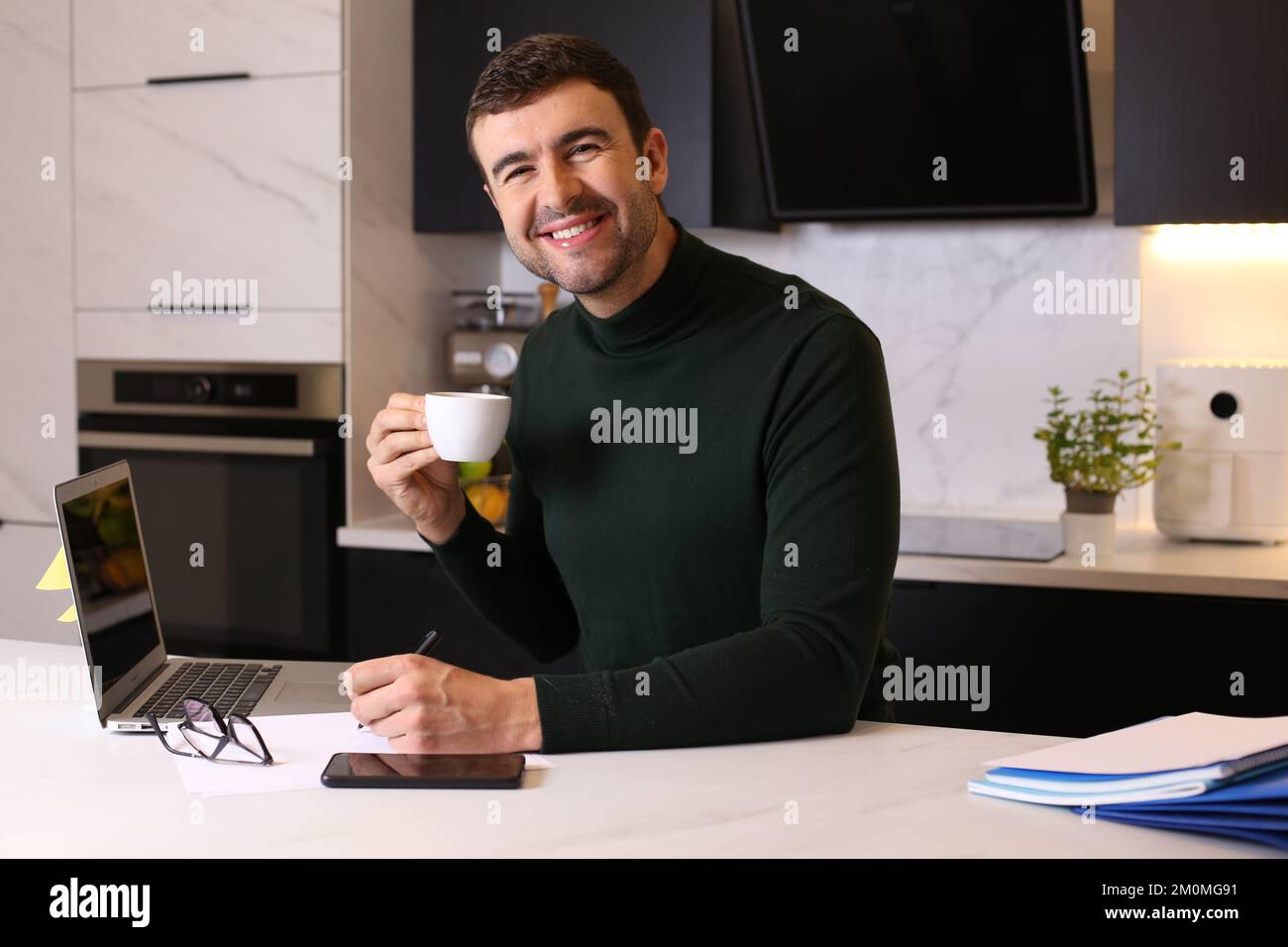 Man drinking a cup of coffee while working from home Stock Photo