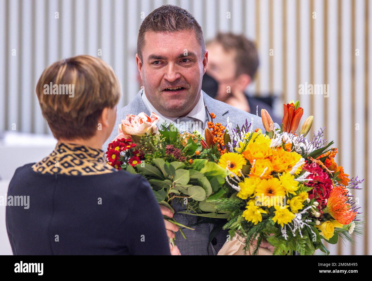 07 December 2022, Mecklenburg-Western Pomerania, Schwerin: Lawyer Sebastian Schmidt receives a bouquet of flowers from Jeannine Rösler, leader of the Left Party in the state parliament of Mecklenburg-Western Pomerania, after his election as the new data protection commissioner for Mecklenburg-Western Pomerania. Schmidt, who had previously worked as a staff member of the Left faction in the state parliament, received 43 of the 71 votes cast in a secret ballot. The members of the Schwerin state parliament are starting the last week of sessions in 2022, with numerous bills before the parliamentar Stock Photo