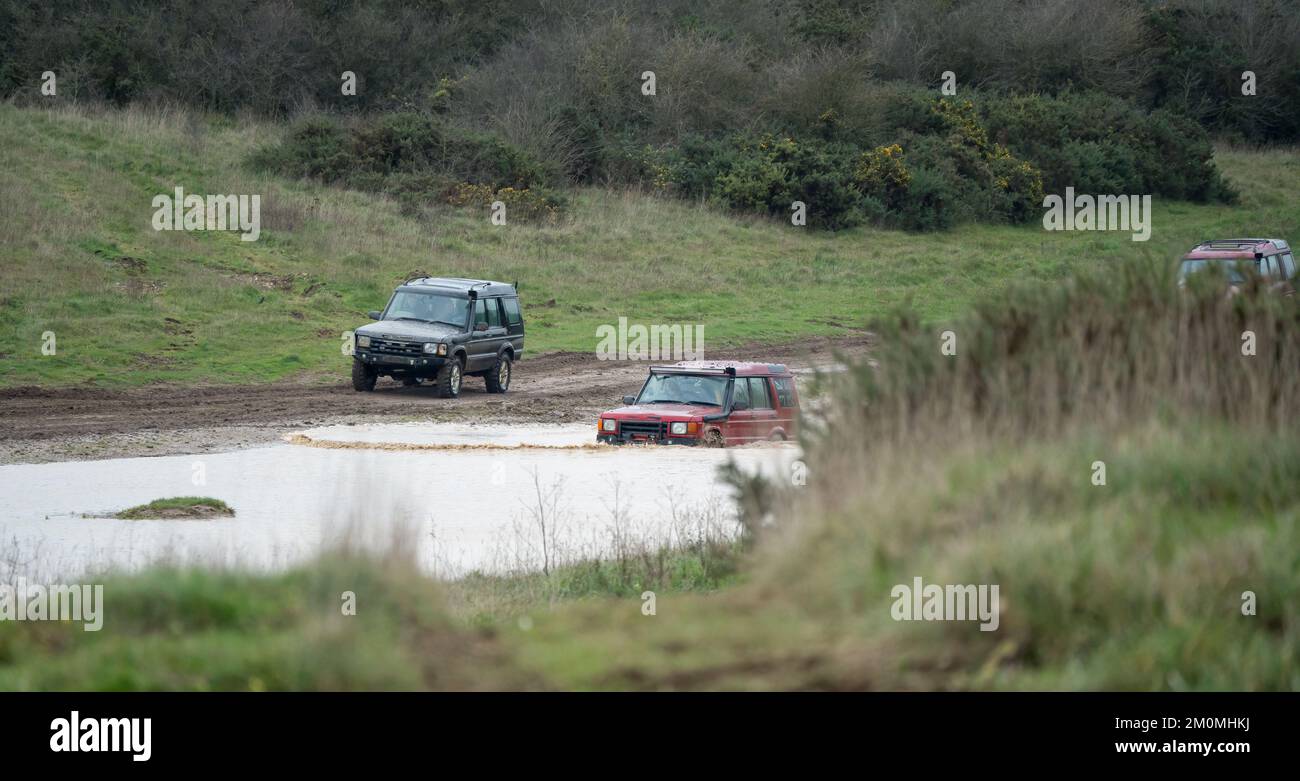 three land rover discovery 4x4 off-road vehicles being driven through ...