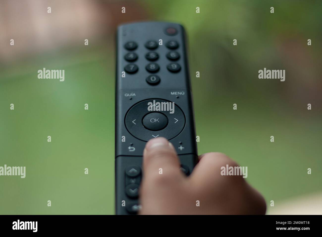 hand directing a television remote where you can see the different