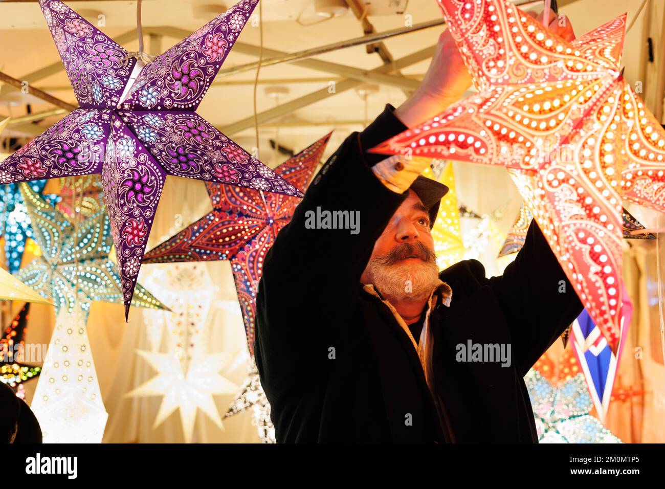 The annual Lincoln Christmas Market held every first weekend in December. The market is held in the uphill area of the City known as Bailgate, mainly around the Cathedral and the Castle. The cathedral if floodlit, in 2022 a blue/purple colour making it a centre piece seen acroos the City. Attracting thousands of people from all over Europe the market at times becomes a one way system to allow the large numbers of people to go around safely. A stall selling colourful lanterns near the castle grounds. Stock Photo