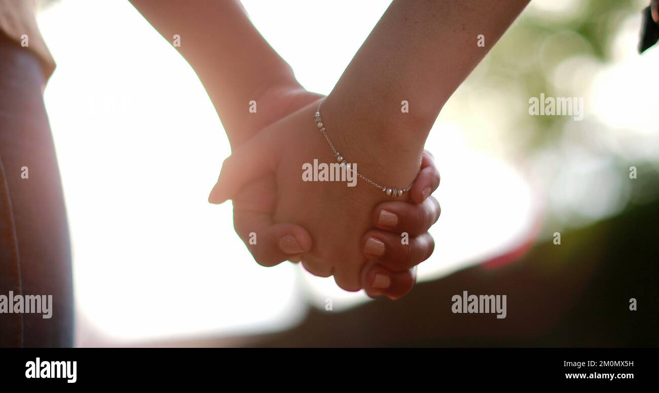 Two friends holding hands together in unity outside in sunlight Stock ...