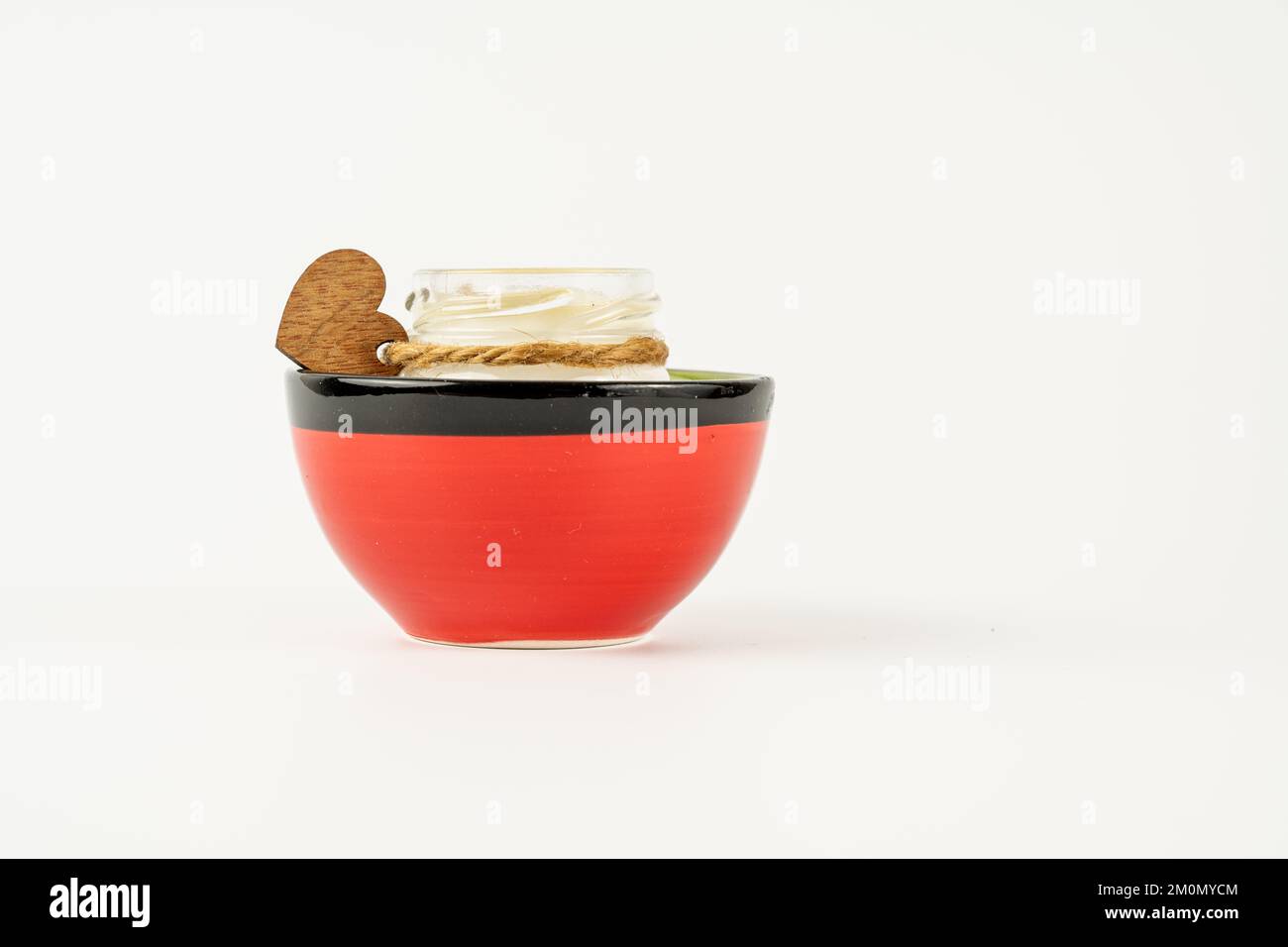 scented candle glass jar in a spanish clay bowl isolated on a white