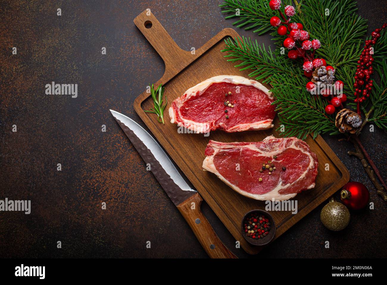 Two raw beef steaks with Christmas festive decoration from above Stock Photo