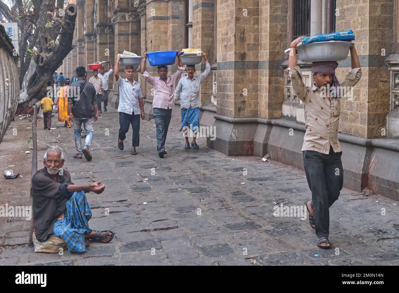 Porters with baskets of fish on their heads, at Chhatrapati Shivaji Maharaj Terminus (CMST), in Mumbai, India, to forward the baskets by train Stock Photo