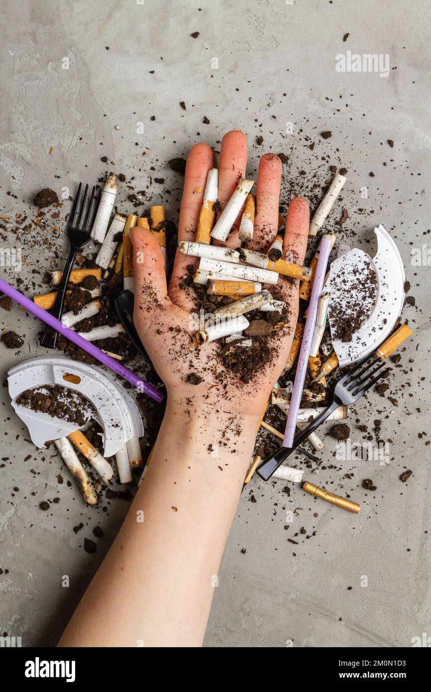 concept cigarettes Hand holding pile of cigarettes with dirt. Concept of enviroment pollution  Stock Photo