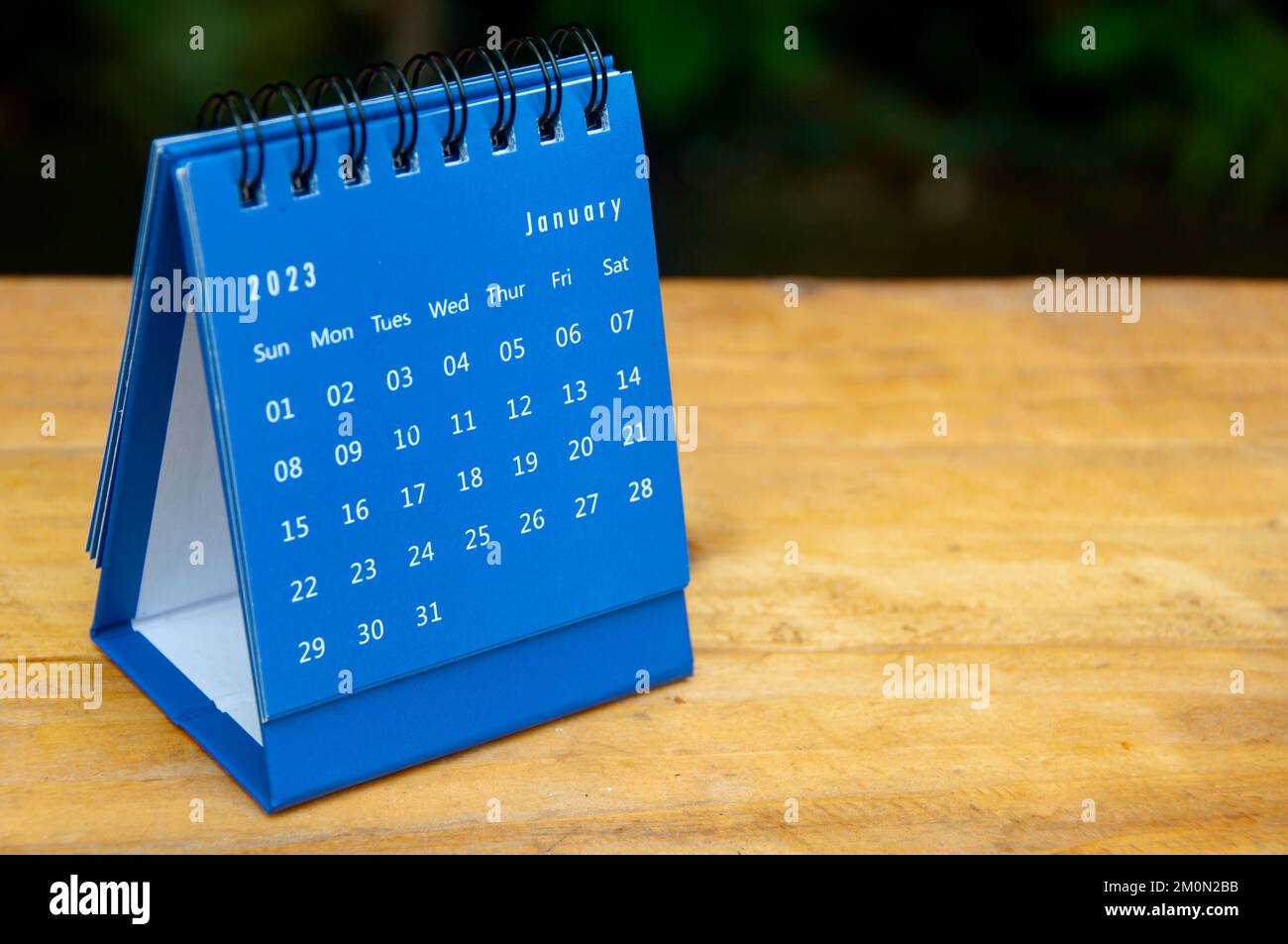 January 2023 blue desk calendar on wooden table background with customizable space for text. Stock Photo