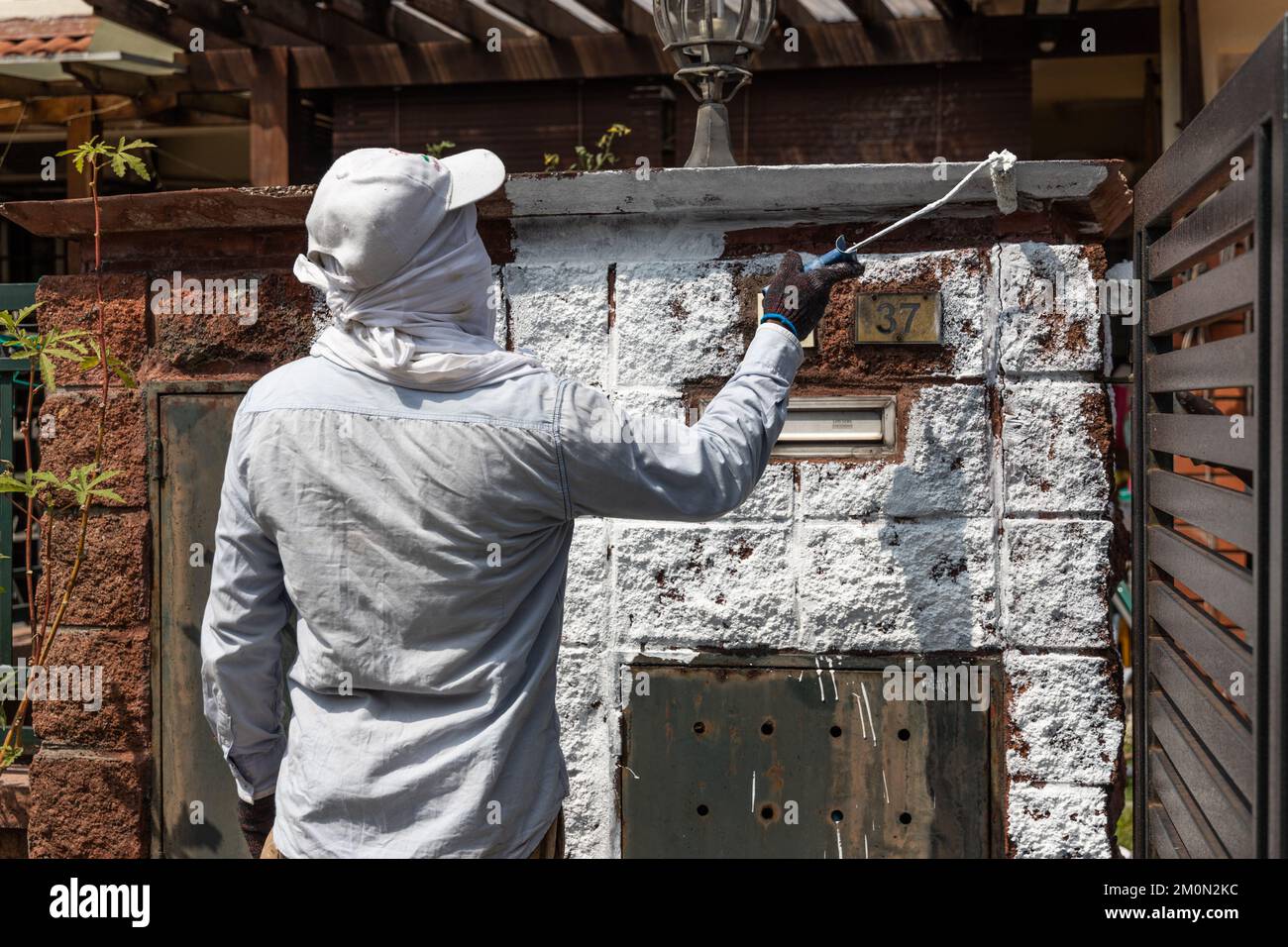 Painter worker adding undercoat foundation paint onto wall with roller