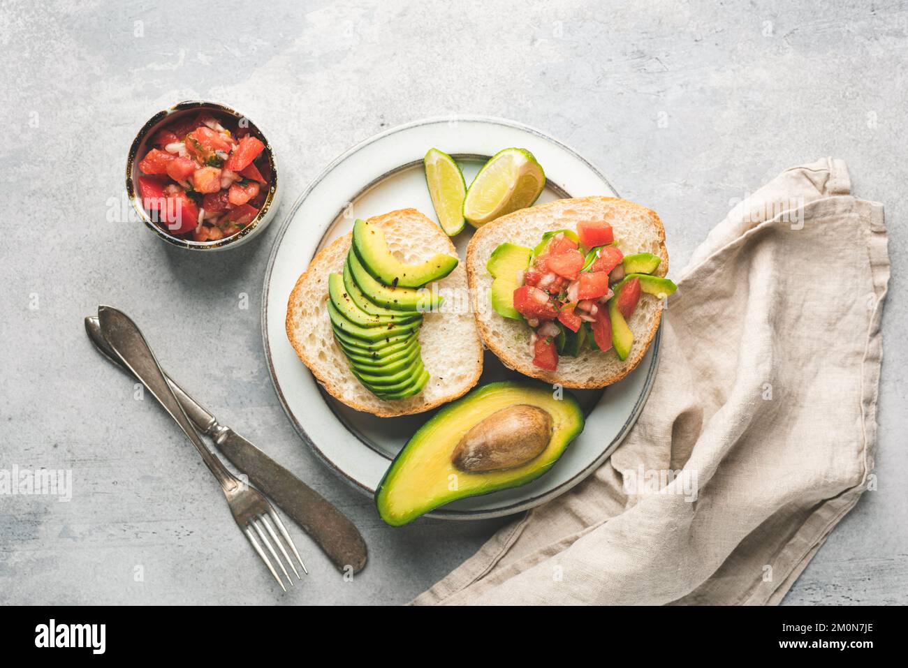 Breakfast avocado toast on english muffin with tomato salsa. Top view. Healthy food Stock Photo