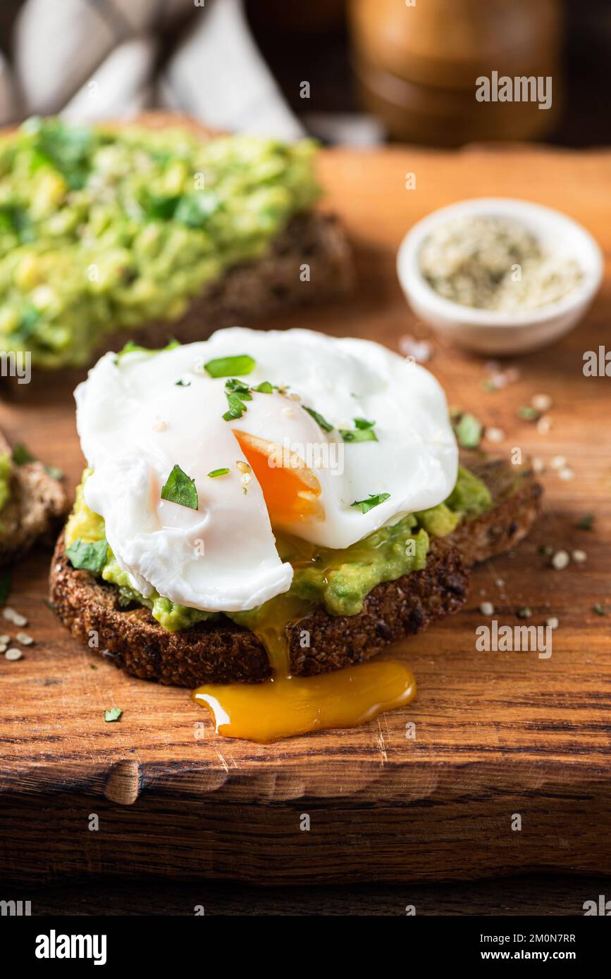 Poached egg on avocado toast. Healthy breakfast, lunch or brunch food. Stock Photo