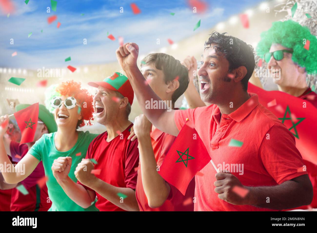 Morocco football supporter on stadium. Moroccan fans on soccer pitch watching team play. Group of fo Stock Photo