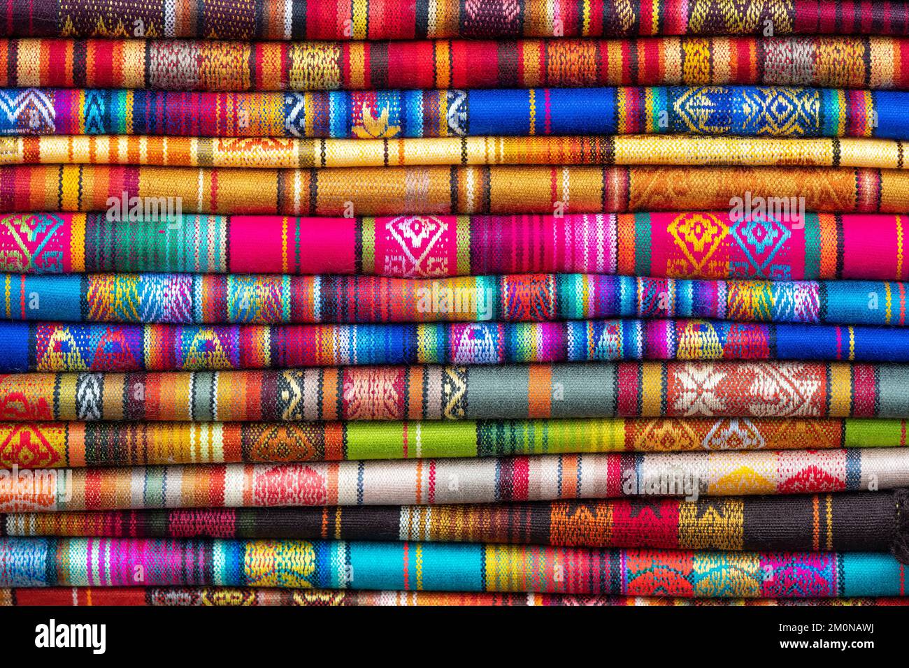 Vibrant colors of traditional Andes textiles on art and craft market, Otavalo, Ecuador. Textiles found in Bolivia, Peru and Ecuador. Stock Photo