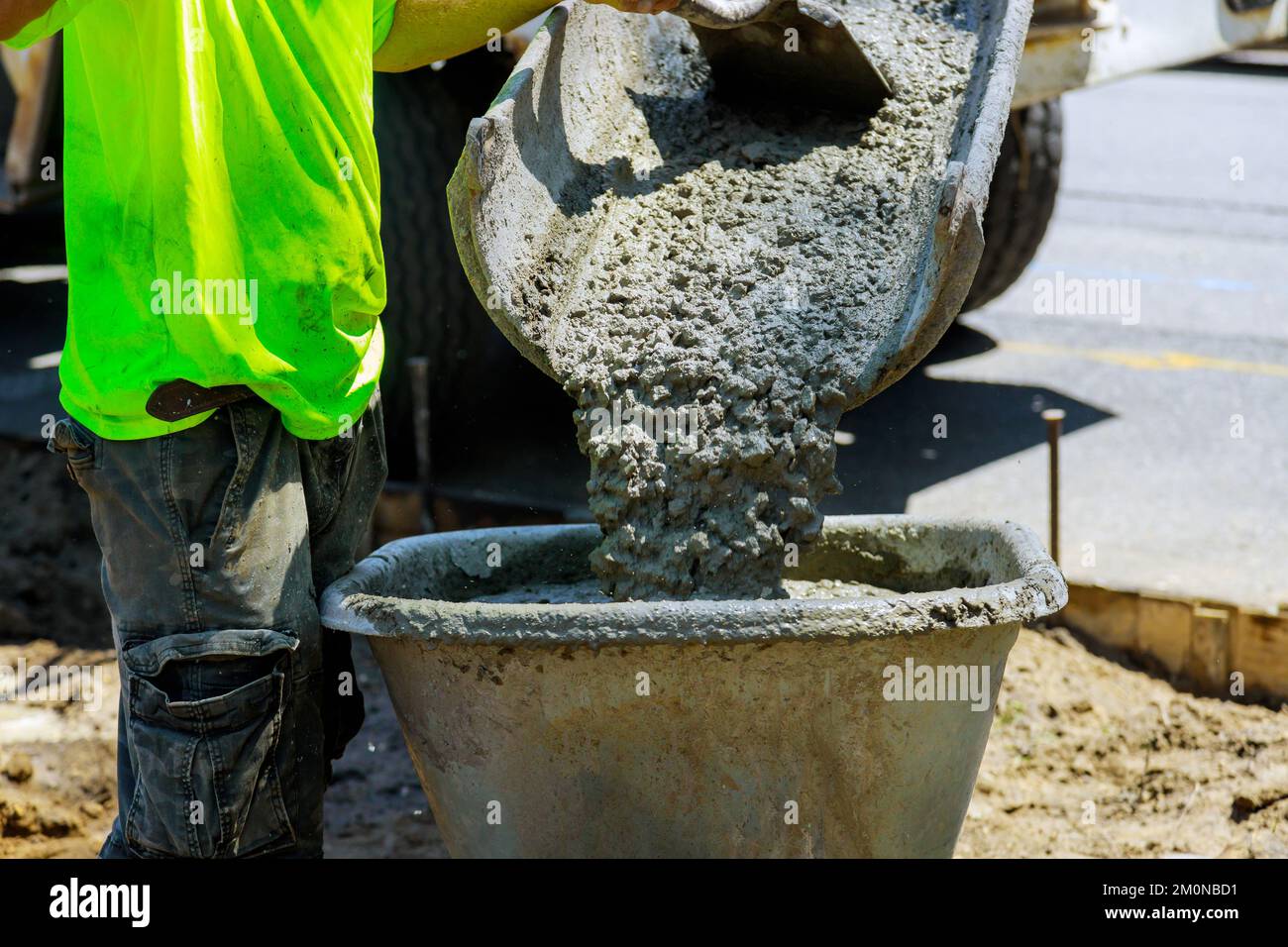 In construction site concrete mixer truck is pouring wet cement into wheelbarrow Stock Photo Alamy