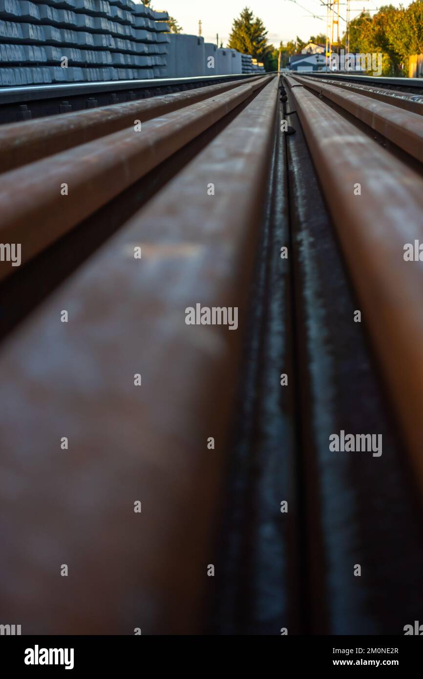 Expansion of railway lines. Train rails ready for laying and concrete sleepers arranged in even piles. Investments in rail transport as the basis for Stock Photo