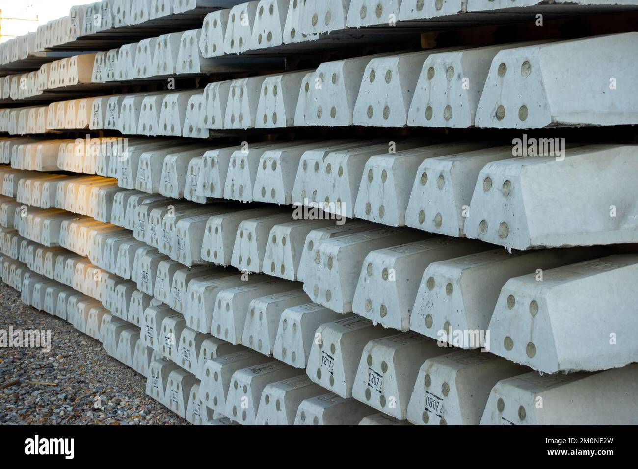 Stacks of concrete railway sleepers at the construction site of a new railway. Investments in rail transport as the basis for development. Stock Photo