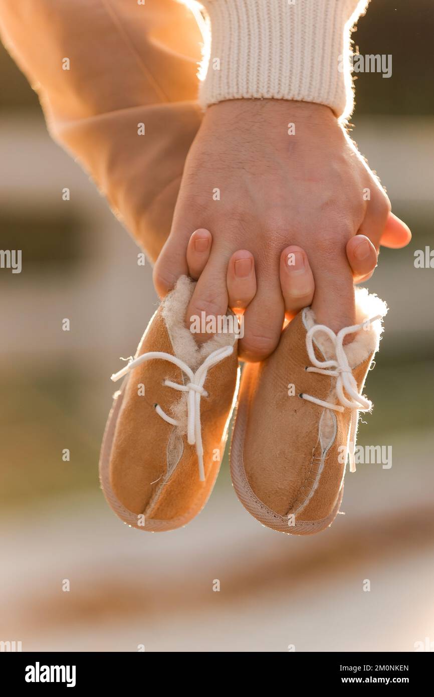 Cropped photo of couple man and pregnant wife are holding hands