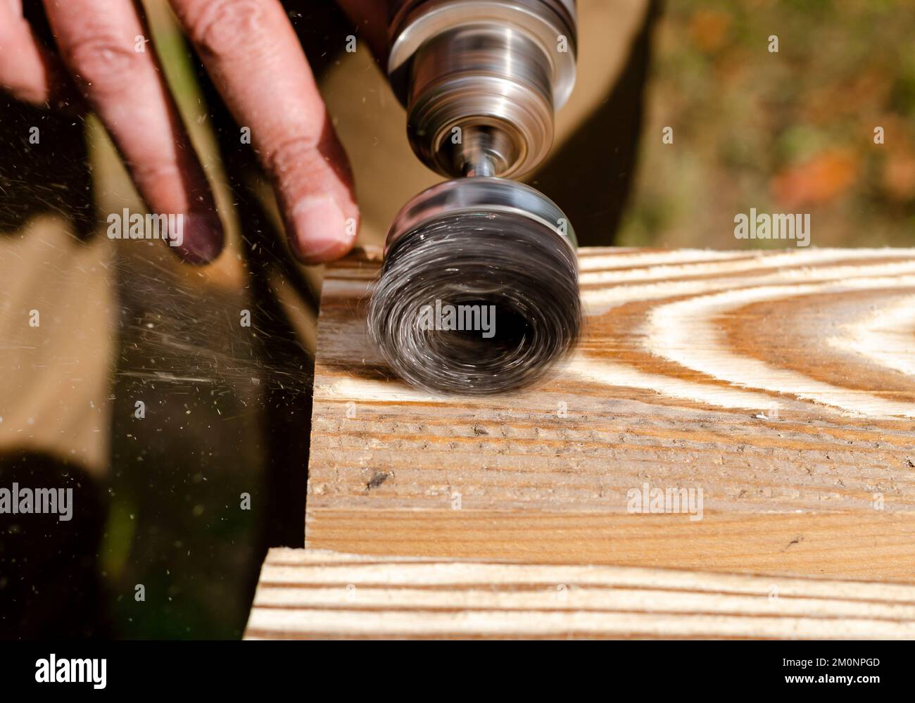 Wood processing. Hands of a man with an electric tool Stock Photo - Alamy