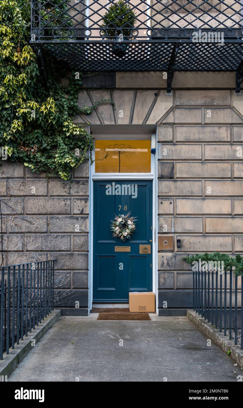 Georgian house front door with Christmas wreath and unattended delivered parcel left on doorstep, Edinburgh New Town, Scotland, UK Stock Photo