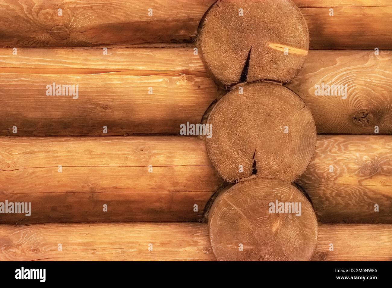 Fragment of a wall made of round wooden logs for use as an abstract background and texture. Stock Photo