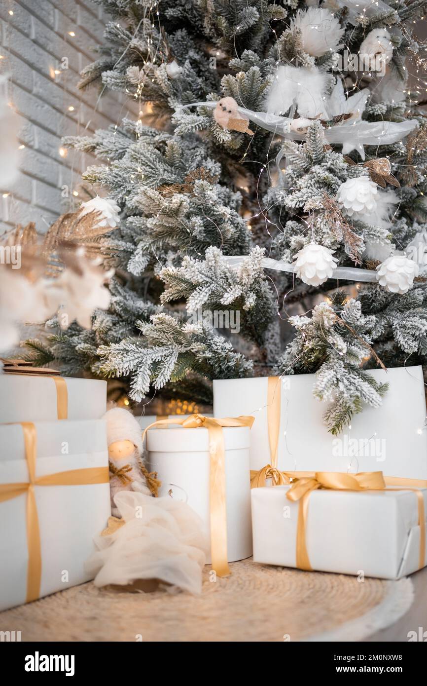 Beautiful Christmas gift boxes on floor near fir tree in room Stock ...
