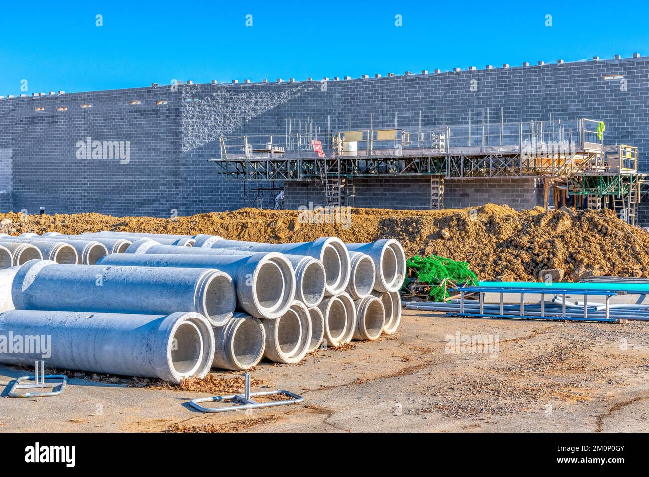 Horizontal shot of scaffolding and drainage pipes at a new commercial construction site. Stock Photo