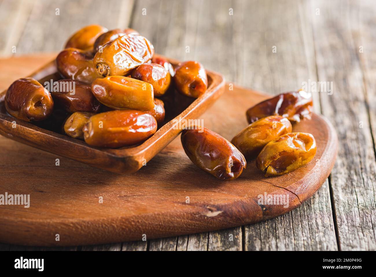 Dried dates fruit in the wooden bowl. Stock Photo