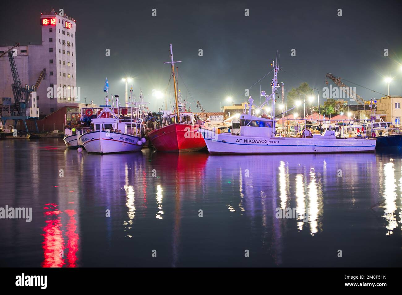 Traditional wooden fishing boats and boats moored in an old port, night photography, Volos Greece Stock Photo