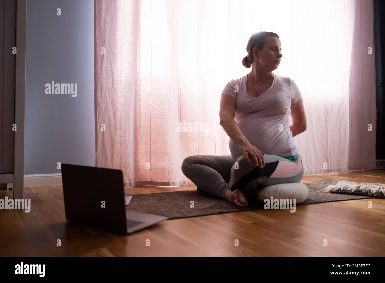 young pregnant woman practices yoga at home Stock Photo - Alamy