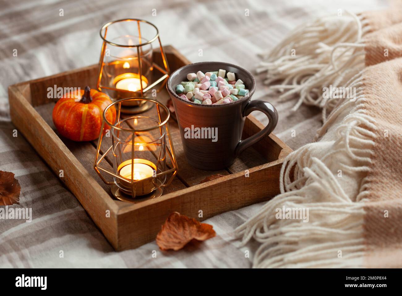 warm cozy bedroom winter or autumn concept, cup of hot chocolate on tray, candles throw Stock Photo