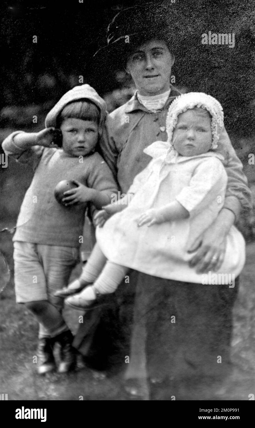 In 1915 Sarah Gregory, aged 39, poses holding her daughter Ida Gregory, aged one, while her son Alfred Gregory, aged two years, stands beside them. Sarah Gregory ran a grocer's shop in Blackburn, Lancashire, UK, with her husband Charles Gregory, who took the photo. Alfred Gregory would go on to be a mountaineer and in charge of stills photography on the 1953 British Mount Everest Expedition which made the first ascent of Mount Everest. Ida Gregory, with her brother and her husband, started a travel agency after World War 2. Charles Gregory died as a soldier in World War 1 in 1918. Stock Photo
