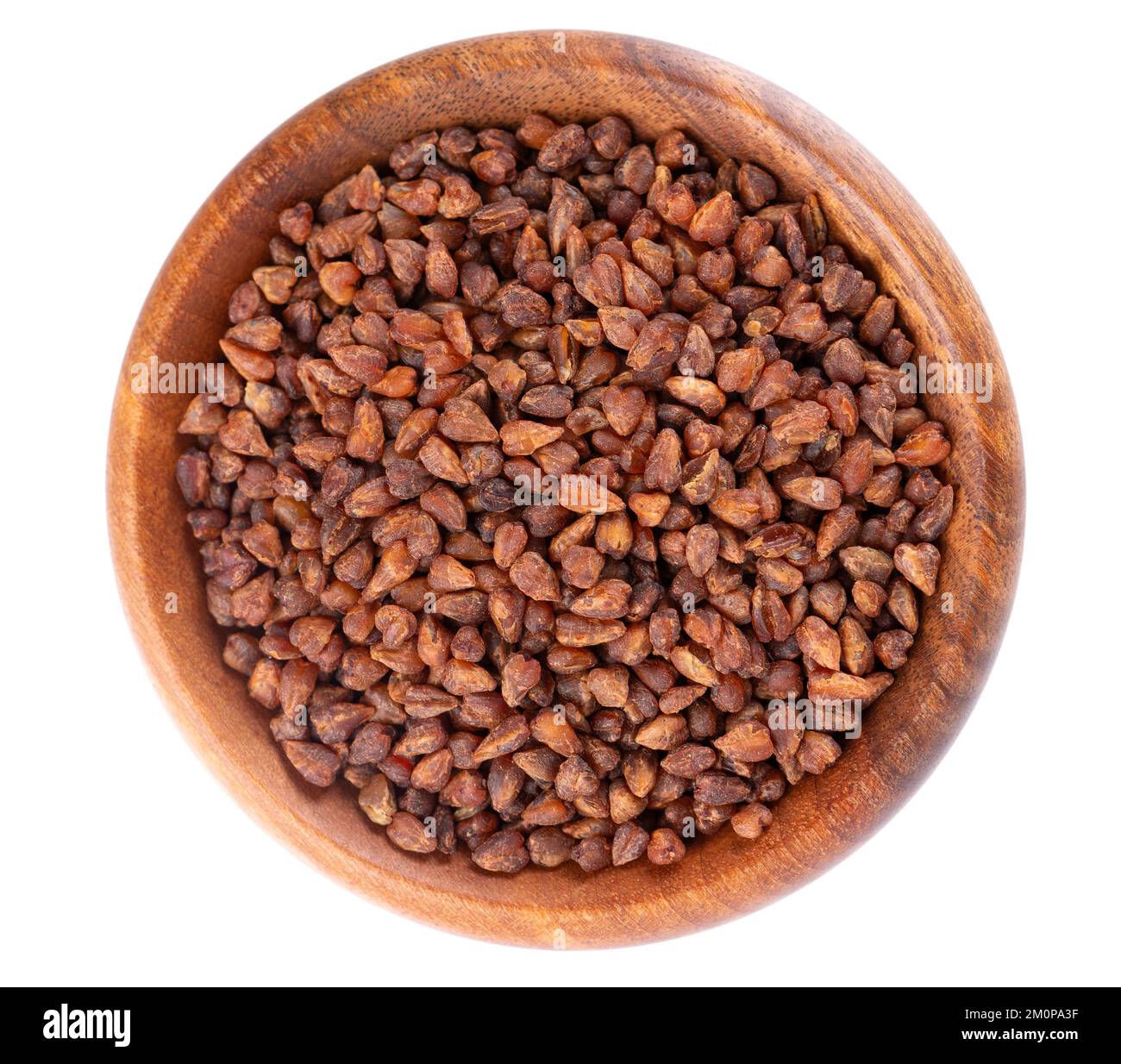Buckwheat tea in wooden bowl, isolated on white background. Whole roasted buckwheat grains. Fagopyrum tataricum. Top view Stock Photo